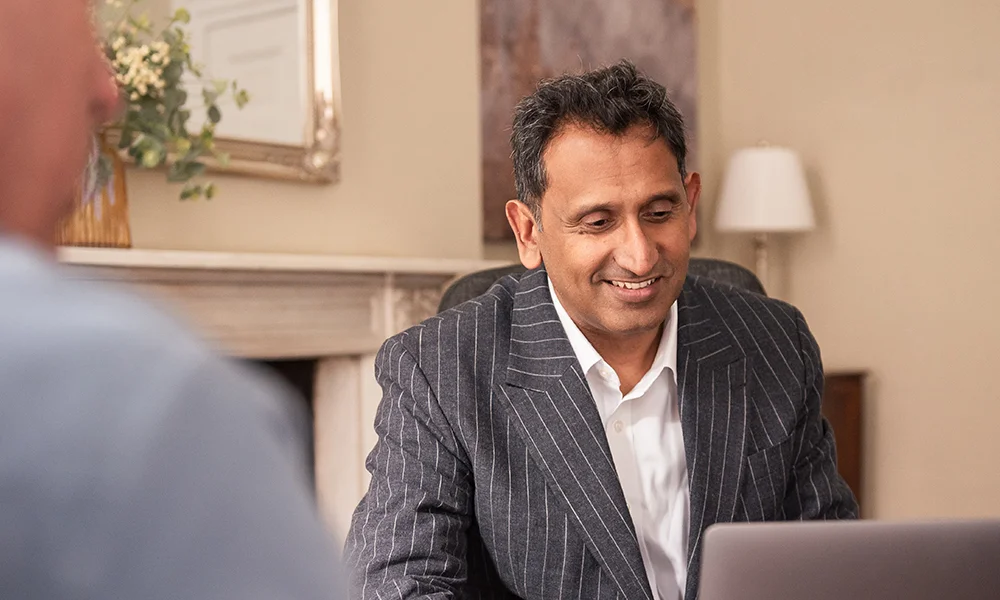Professor Prasanna Sooriakumaran smiling during a consultation with a patient