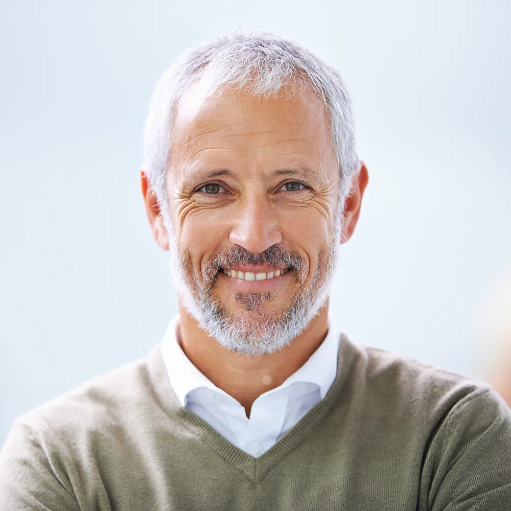 Smiling grey-haired man, representing prostate screening for men